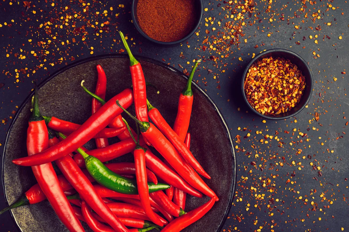 | Every Ingredient Close-up of vibrant red Korean chili flakes (gochugaru) in a small ceramic bowl, highlighting texture and color.
